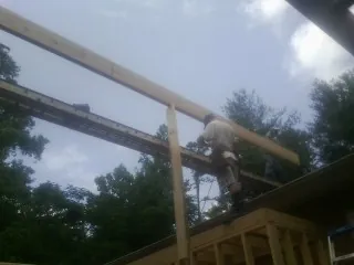 Carpenter setting a ridge beam over a new addition frame — Ice Dam Removal by Roofing Brothers in Guinda
