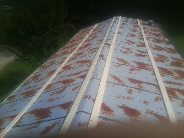 Rusted metal roof panels with new wood purlins before replacement — Storm Damage Roof Repair in Guinda by Roofing Brothers