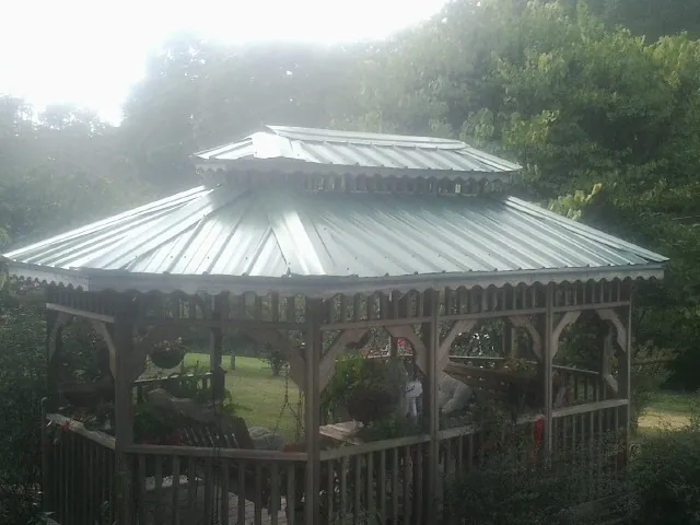 Two tier green metal roof on a garden gazebo in Guinda